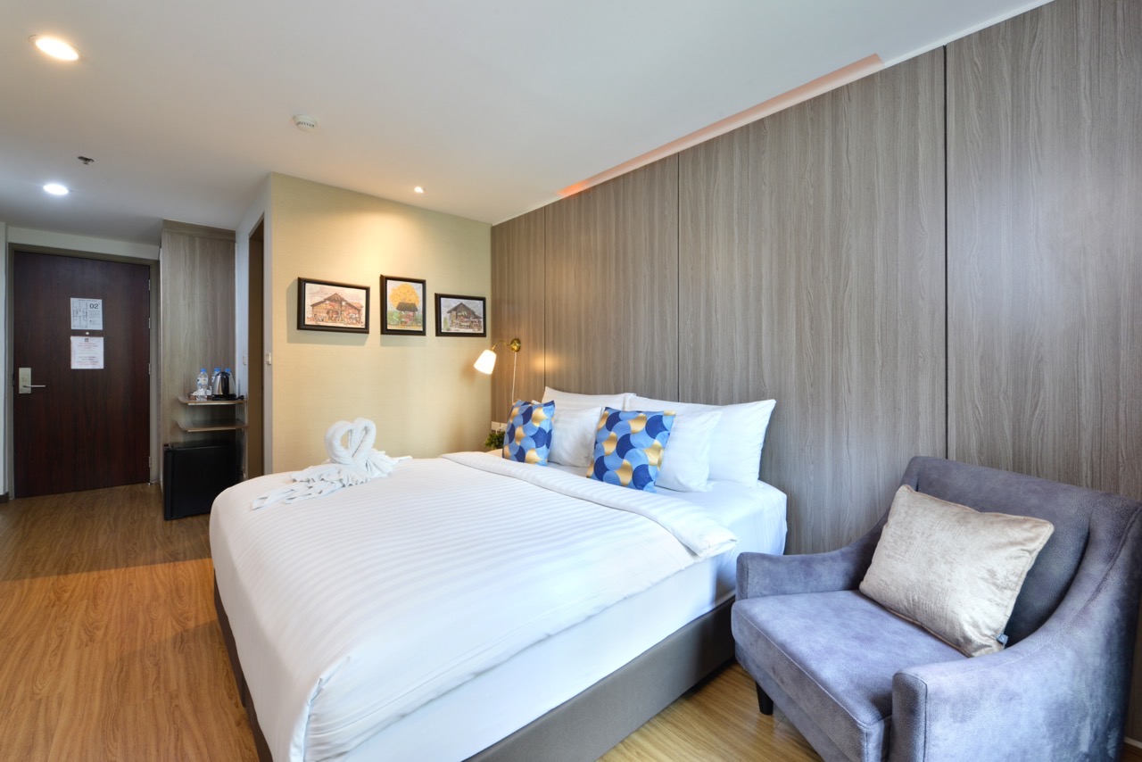 A king bed and armchair in a Superior King room at StayAt Bedever