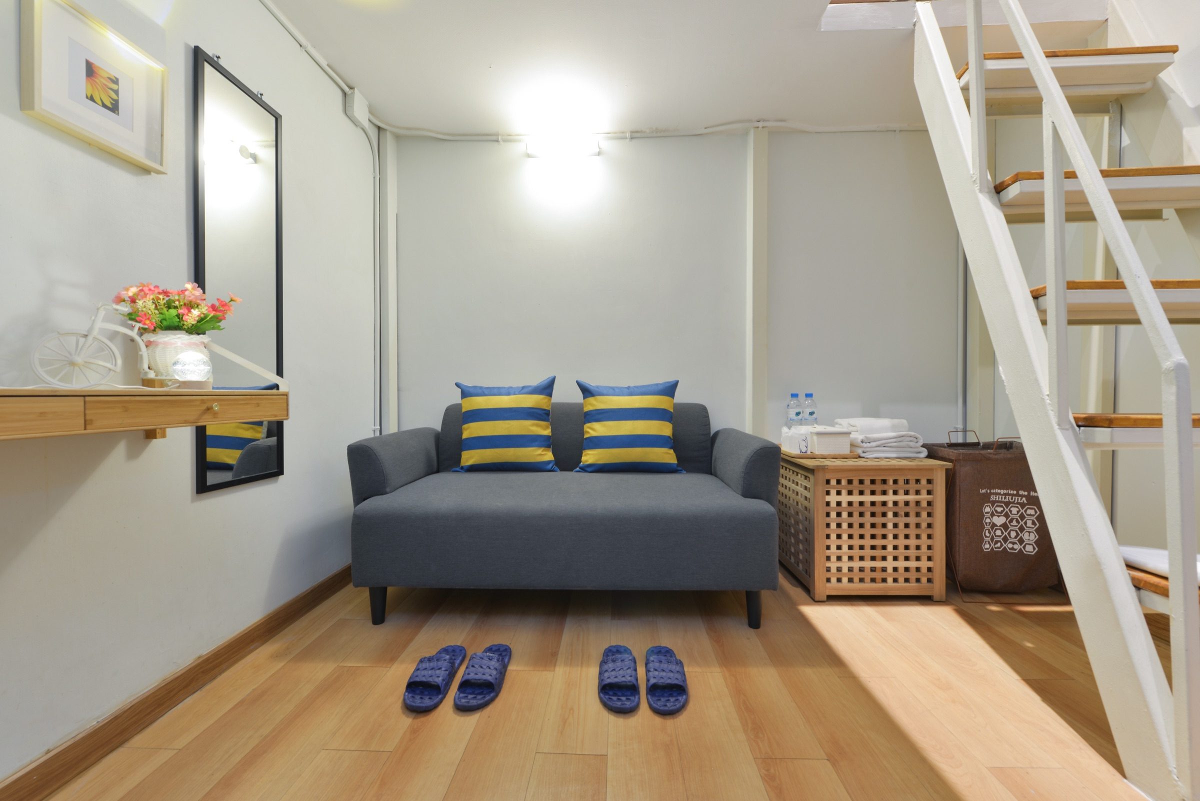 The lounge of a Loft Studio at StayAt Bedever, with a sofa and the stair-ladder up to the sleeping deck